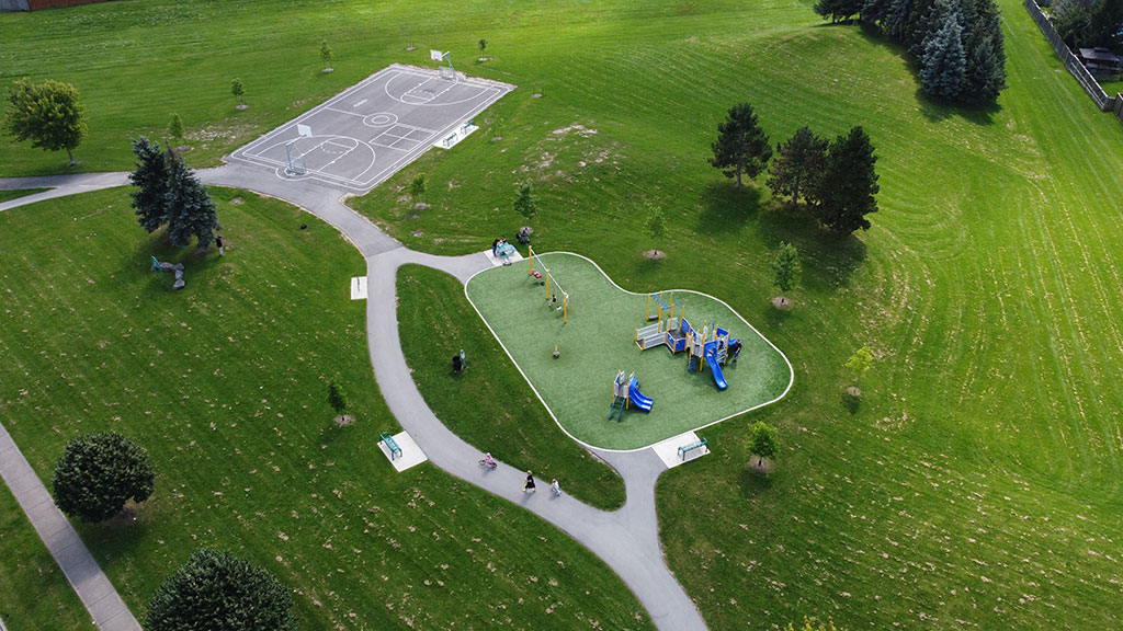 Drone overhead photo of Alpine Prak showing the playground, walking paths and basketball court.